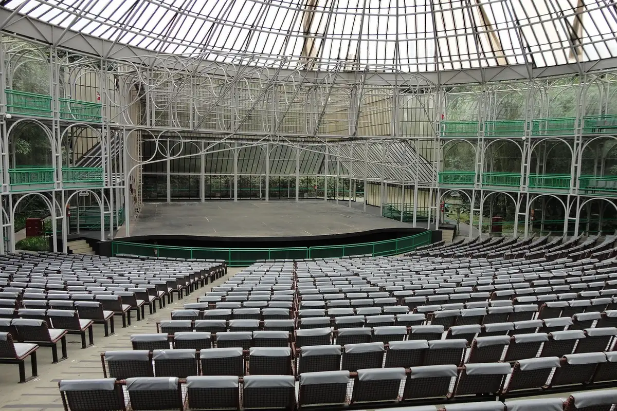 Teatro Ópera de Arame em Curitiba visto de frente, com estrutura metálica sobre o lago