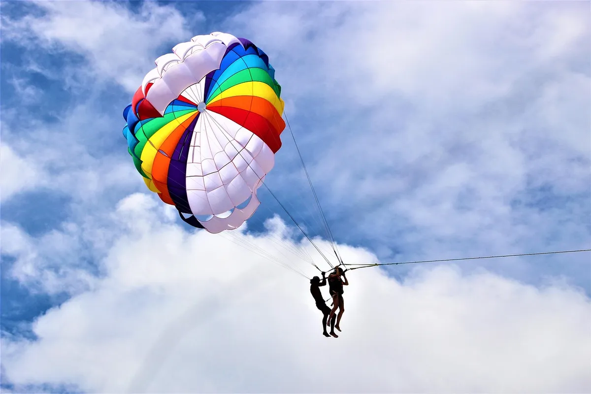 Patong Beach em Phuket com parasailing e turistas na areia
