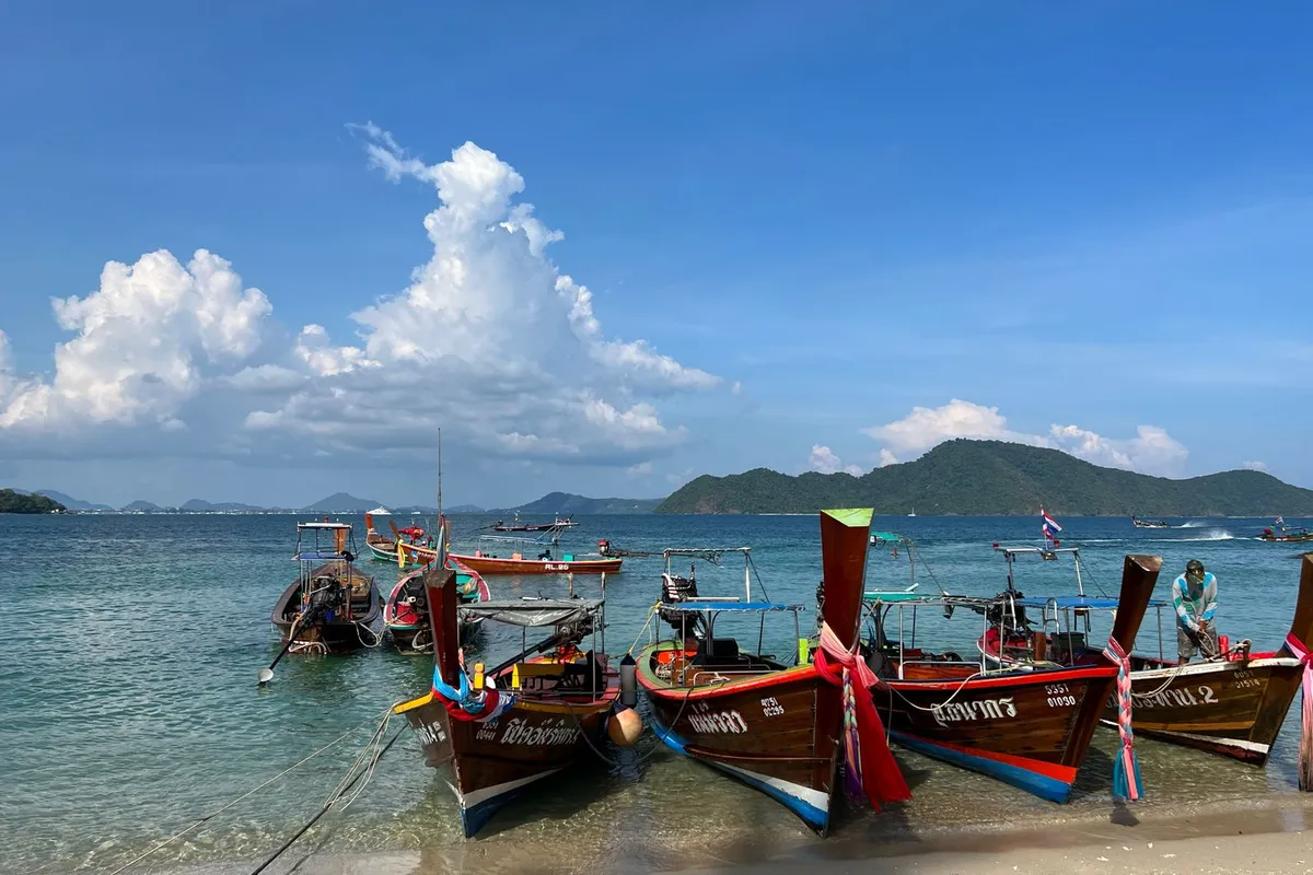 Barcos longtail ancorados em praia de Phuket na Tailândia