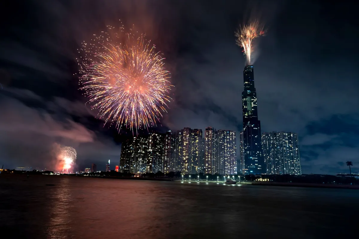 Fogos de artifício iluminando o céu sobre a cidade e o rio na noite de réveillon