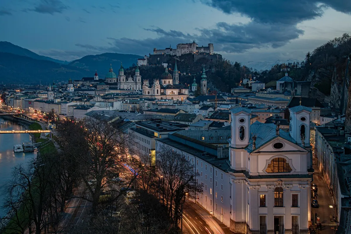 Rio Salzach e cidade de Salzburg ao entardecer