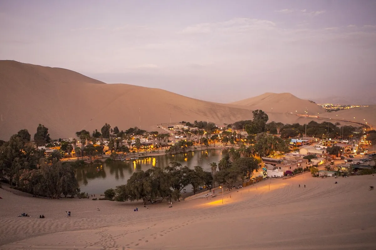 Pessoa praticando sandboard nas dunas de Huacachina