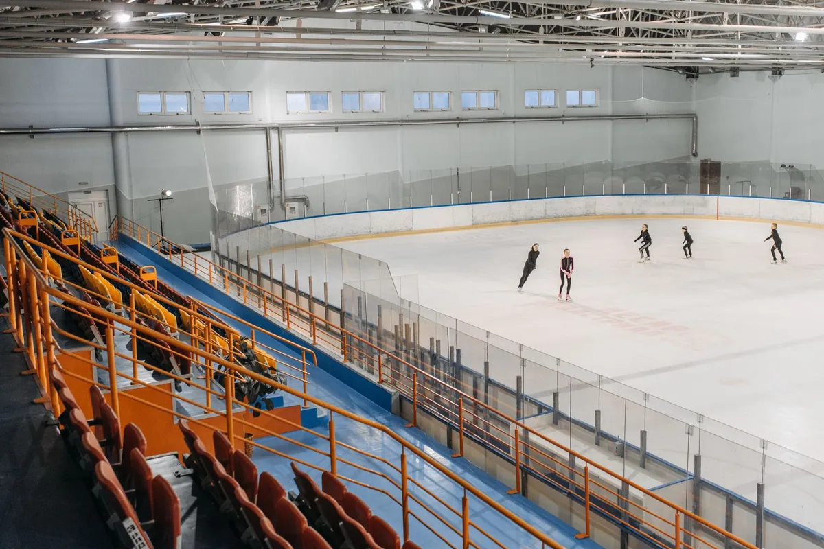 Pessoas patinando em pista de gelo coberta, como no Snowland de Gramado