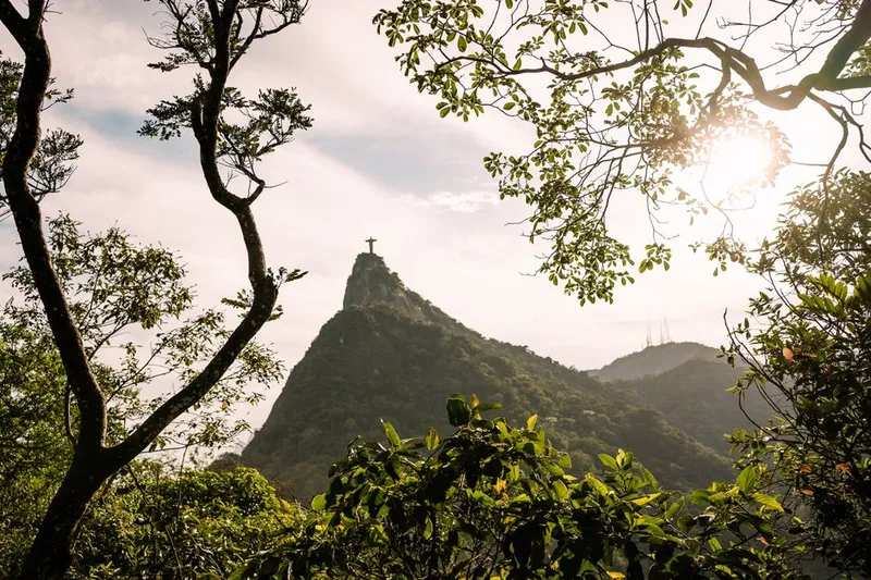 Vista do Cristo Redentor entre arvores no Parque Nacional da Tijuca