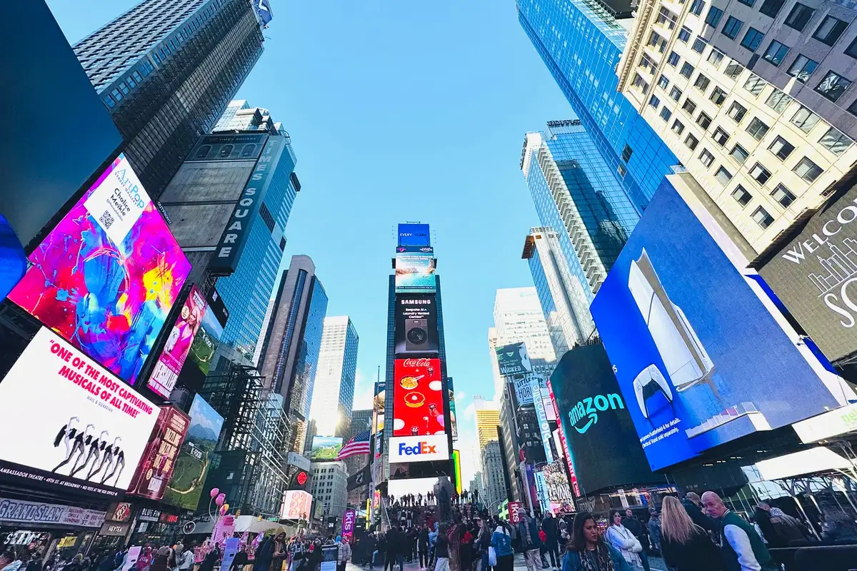Times Square lotada de turistas durante o dia em Nova York