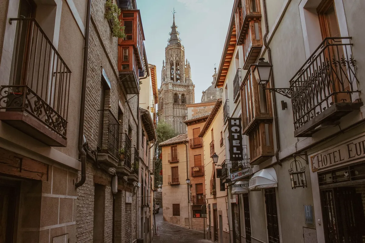 Rua estreita no centro histórico de Toledo com a torre da Catedral