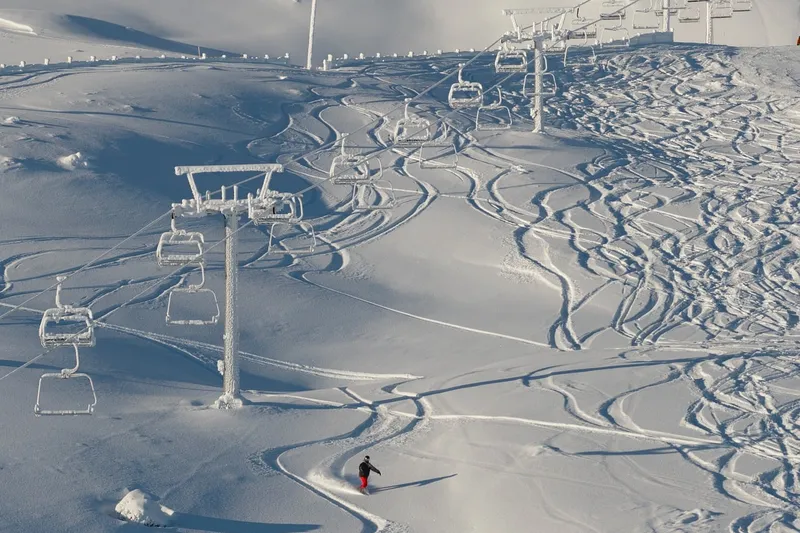 Esquiador em pista cercada por neve