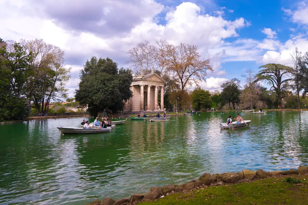 Pessoas passeando de barco no lago da Villa Borghese em Roma