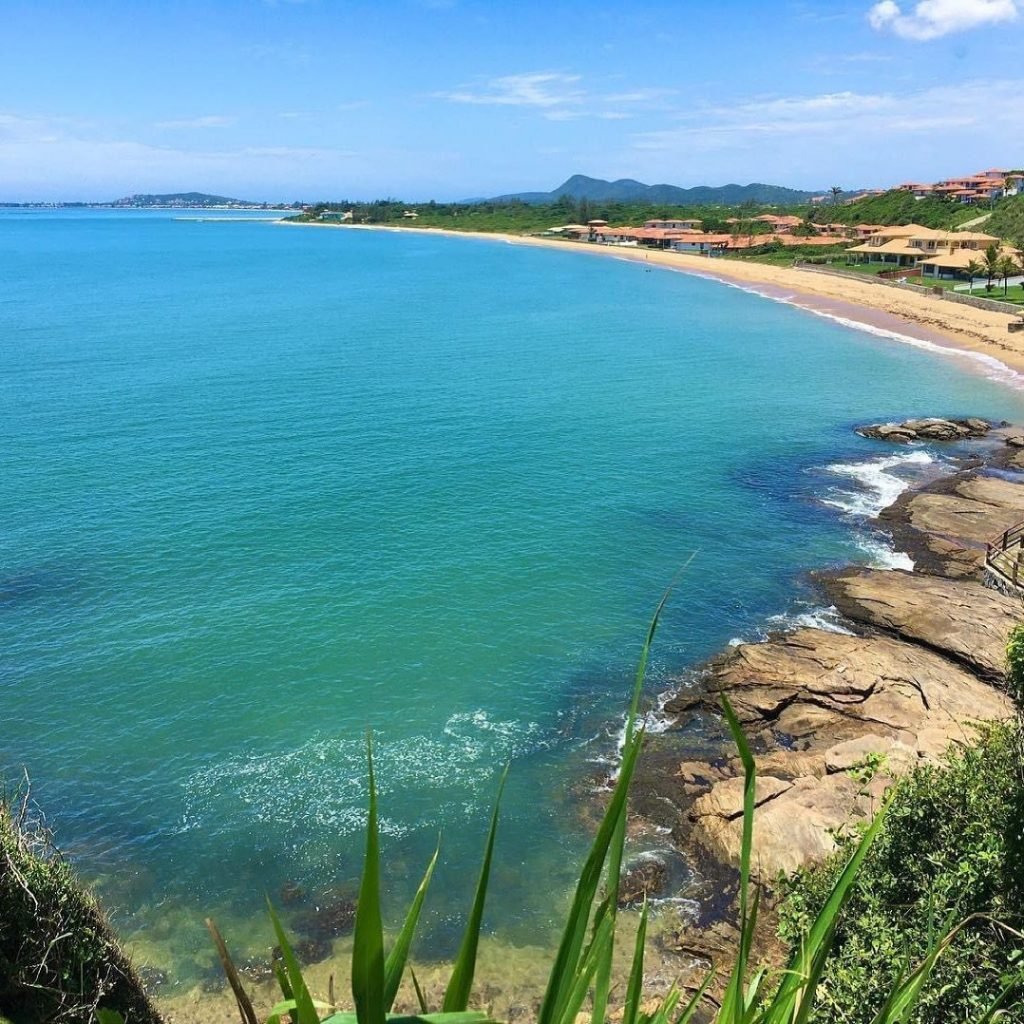 Litoral de Búzios visto de um mirante, com mar, faixa de areia e morros ao fundo