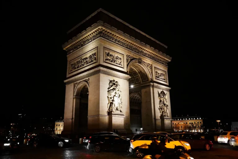 Arco do Triunfo iluminado à noite em Paris, palco do espetáculo de Réveillon