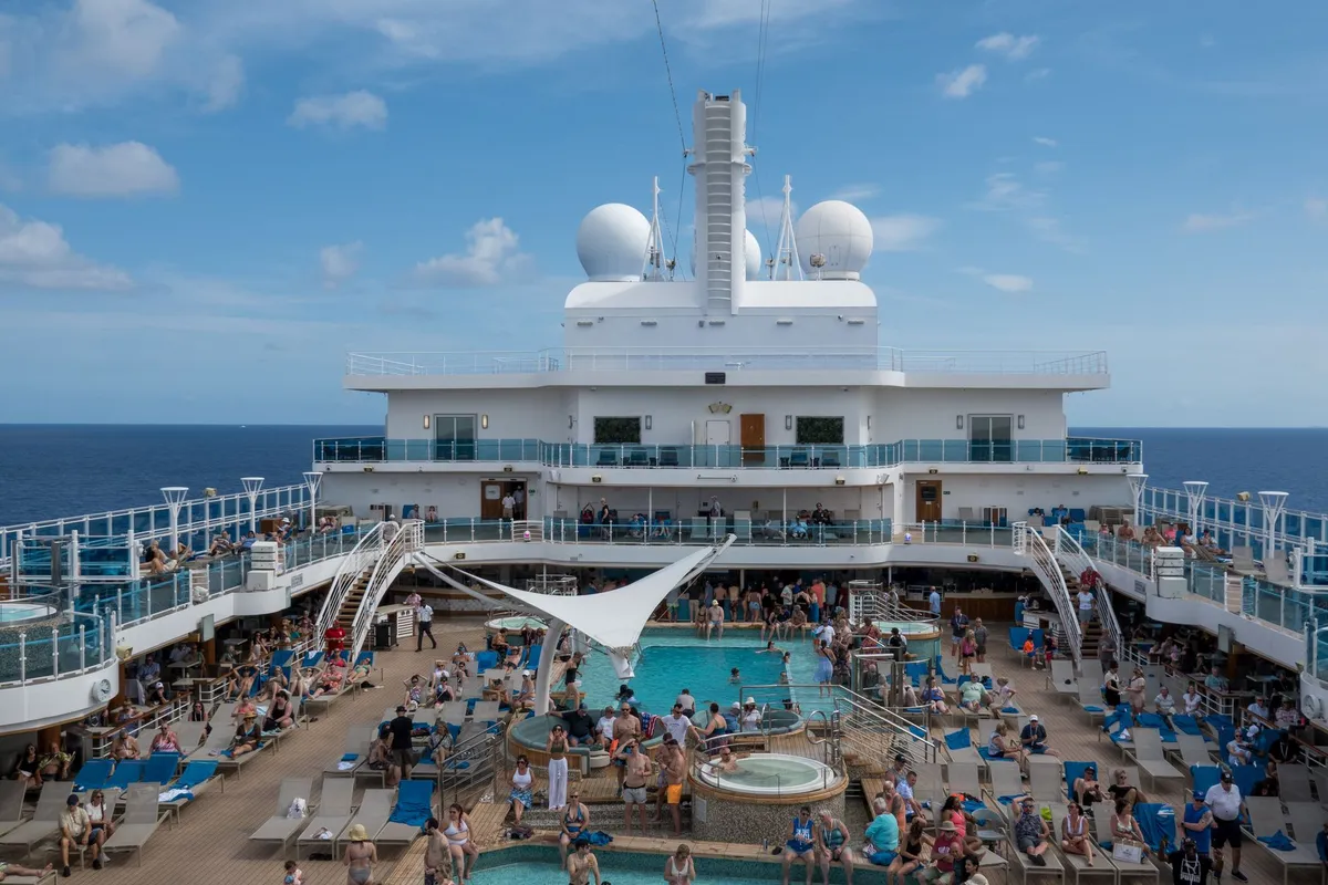 Piscina e deck com passageiros em navio de cruzeiro no verão, cenário típico do Costa Diadema