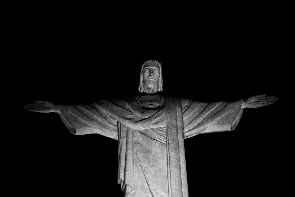 Cristo Redentor iluminado à noite visto da Zona Sul do Rio de Janeiro