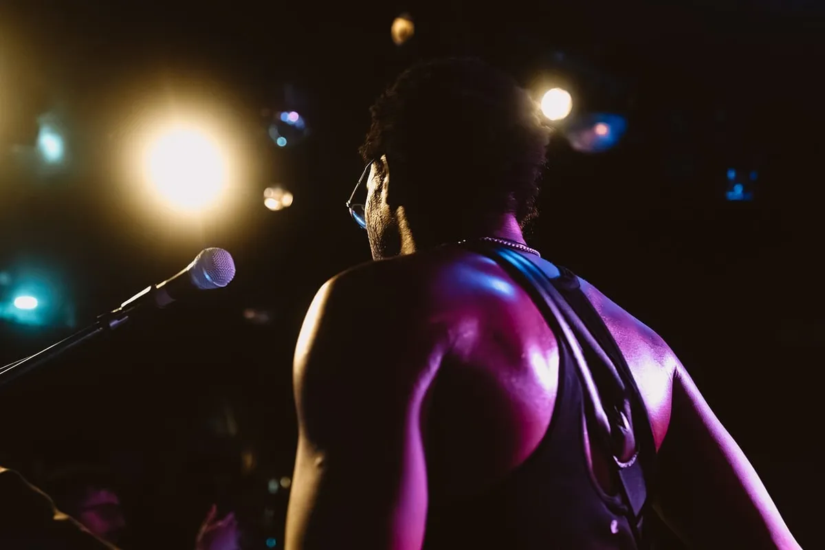 Músico sob holofotes durante apresentação ao vivo
