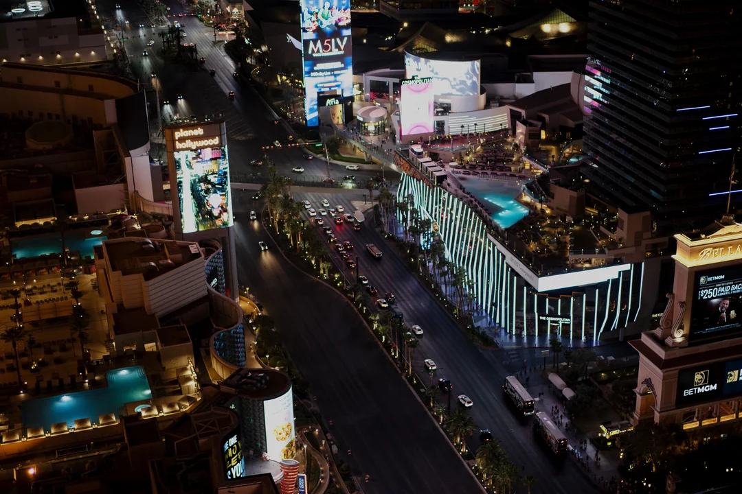 Vista aérea noturna da Las Vegas Strip com hotéis, letreiros e o fluxo da avenida