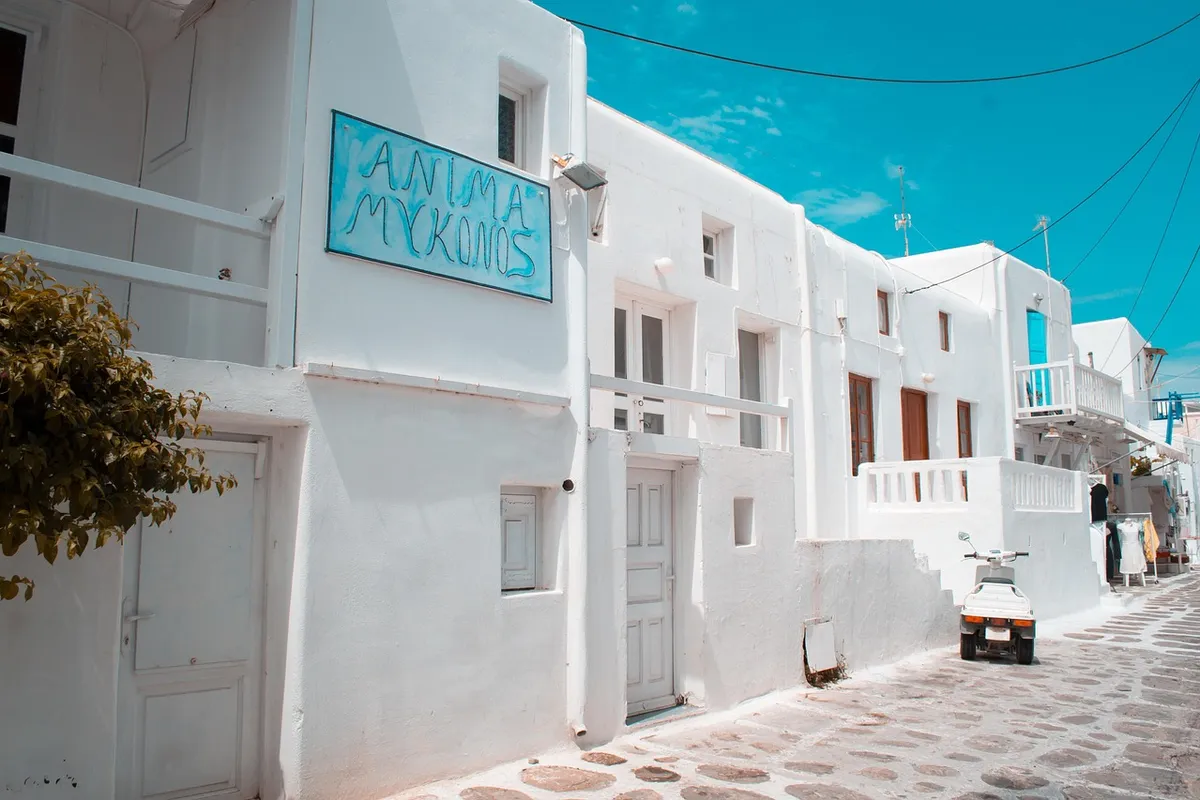 Rua tradicional de Mykonos com casas brancas e detalhes azuis
