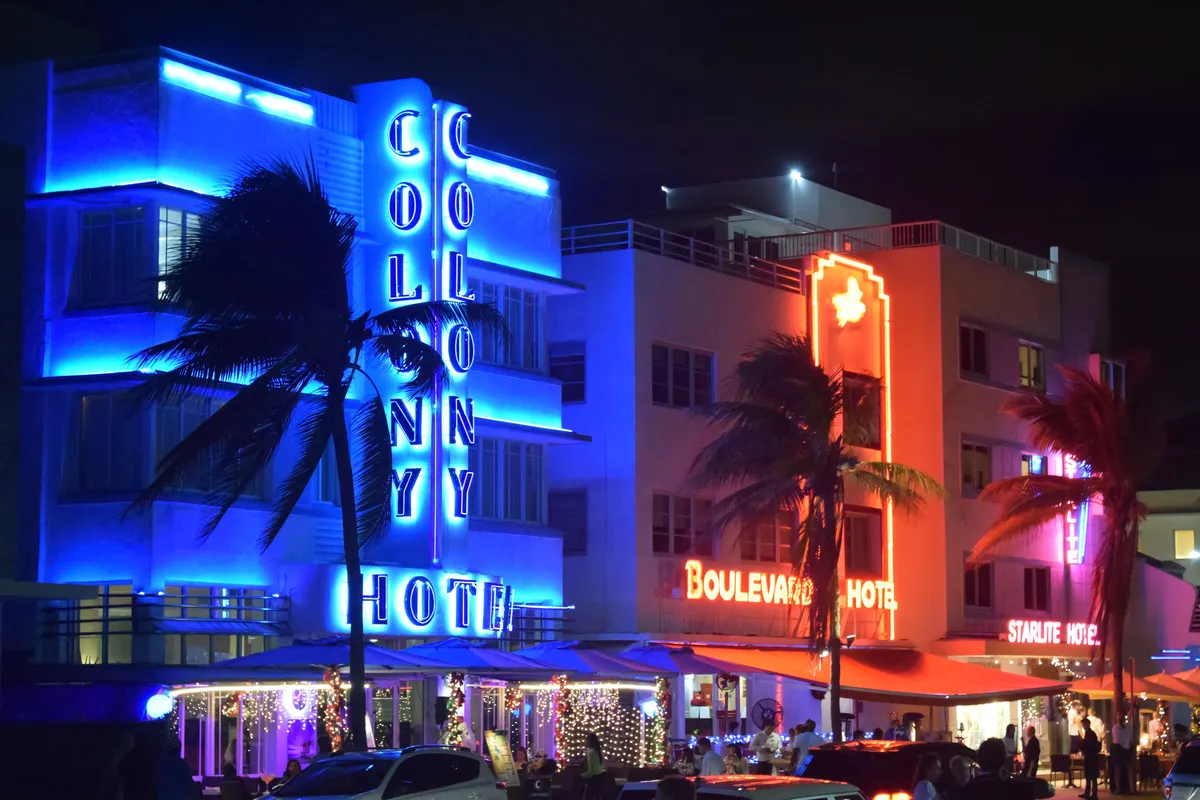 Fachadas art déco iluminadas em azul e vermelho na Ocean Drive, Miami Beach
