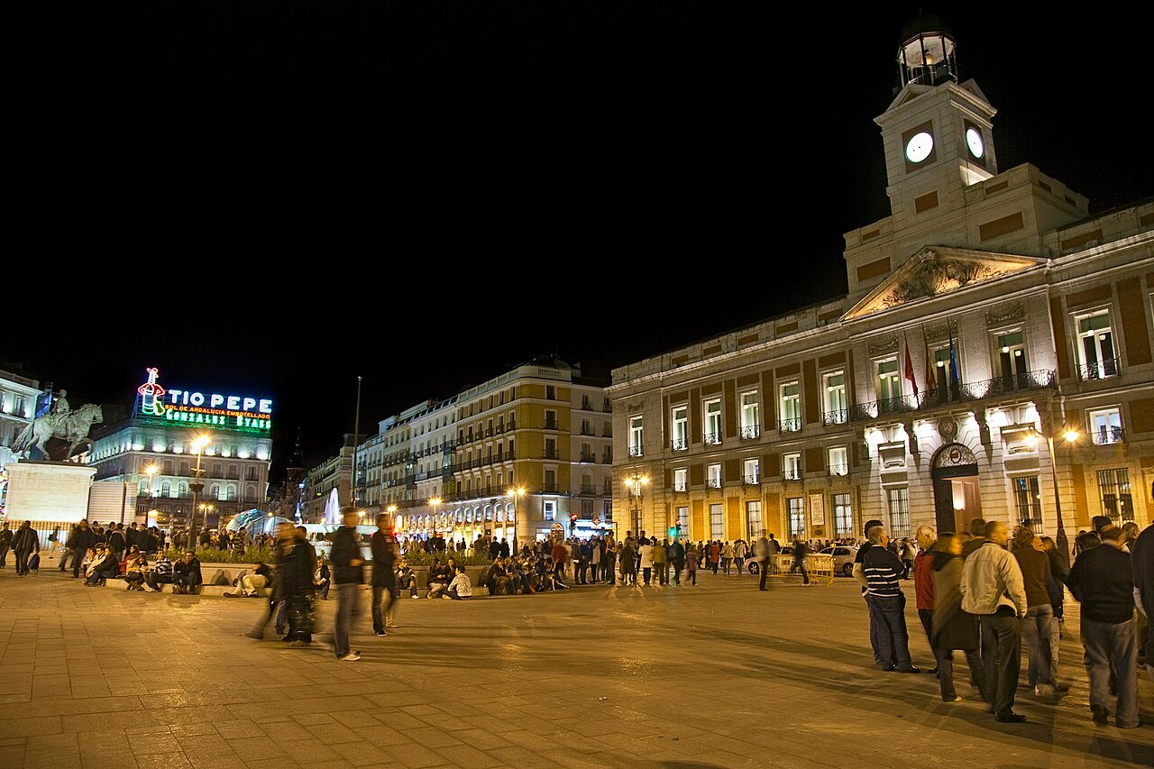Vista noturna da Puerta del Sol, com o relógio da Real Casa de Correos iluminado