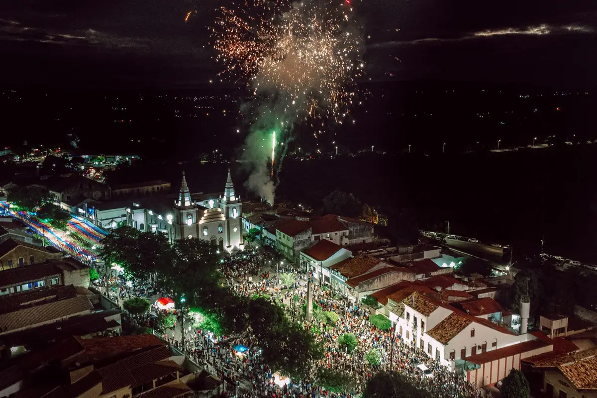Fogos de artifício vistos de cima sobre multidão na praia