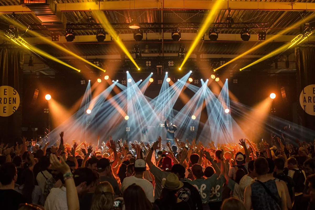 Plateia diante de palco iluminado em show; foto ilustrativa