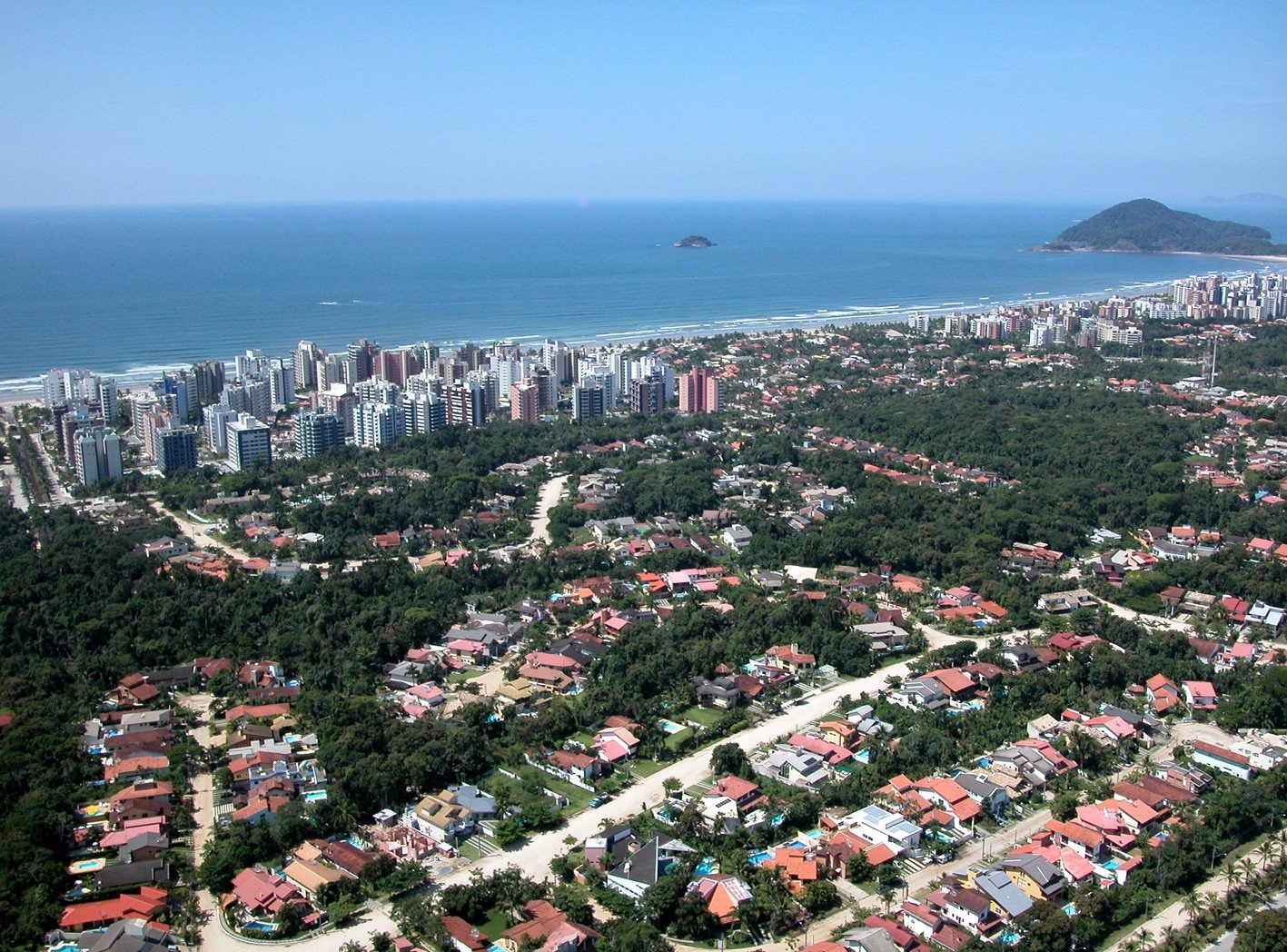 Vista aérea da Riviera de São Lourenço, com a orla, os edifícios e a Mata Atlântica.