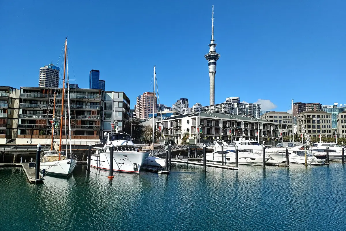 Barcos no Viaduct Harbour com a Sky Tower e edifícios de Auckland ao fundo