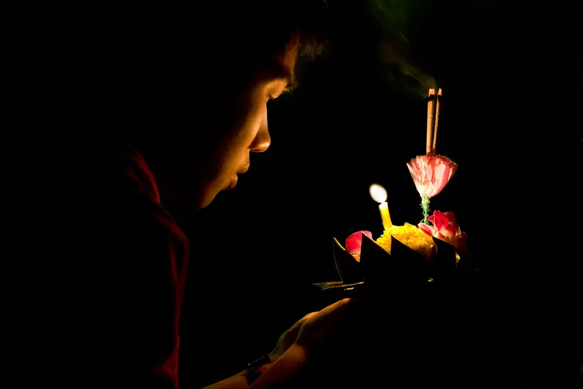 Participante segura krathong com vela durante Loy Krathong no parque Lumpini em Bangkok