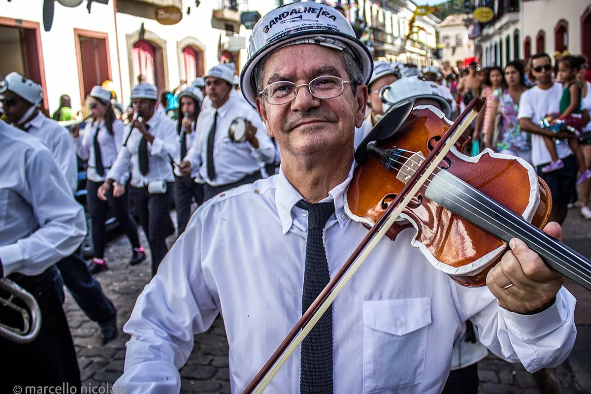 Músico de banda tocando violino em desfile de bloco no Carnaval de Ouro Preto