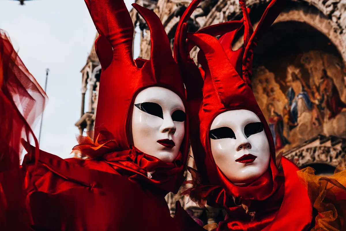 Foliões com fantasias de época e máscaras no Carnaval de Veneza