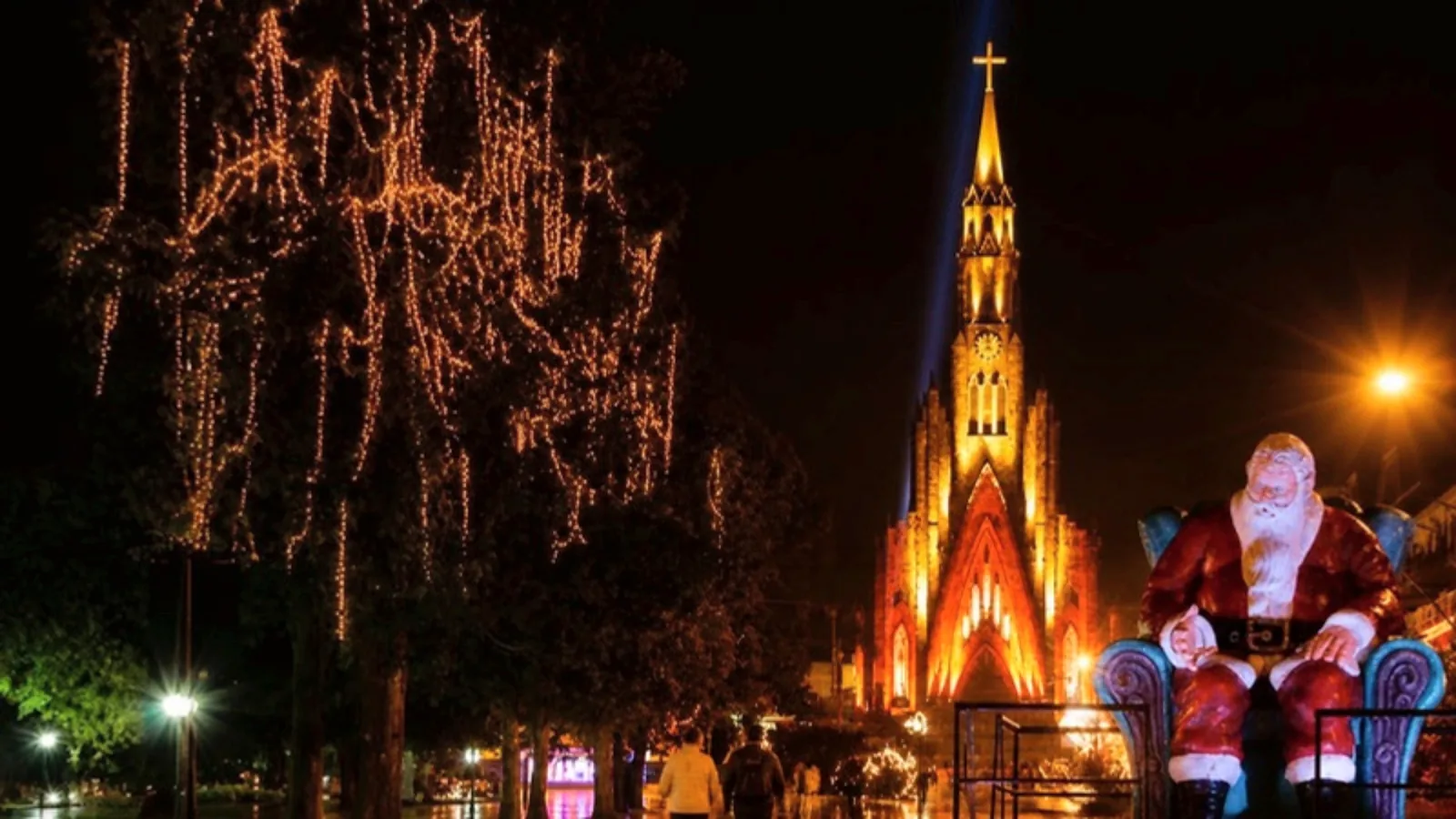 Catedral de Pedra iluminada vista da praça com o Papai Noel e luzes de Natal, em Canela