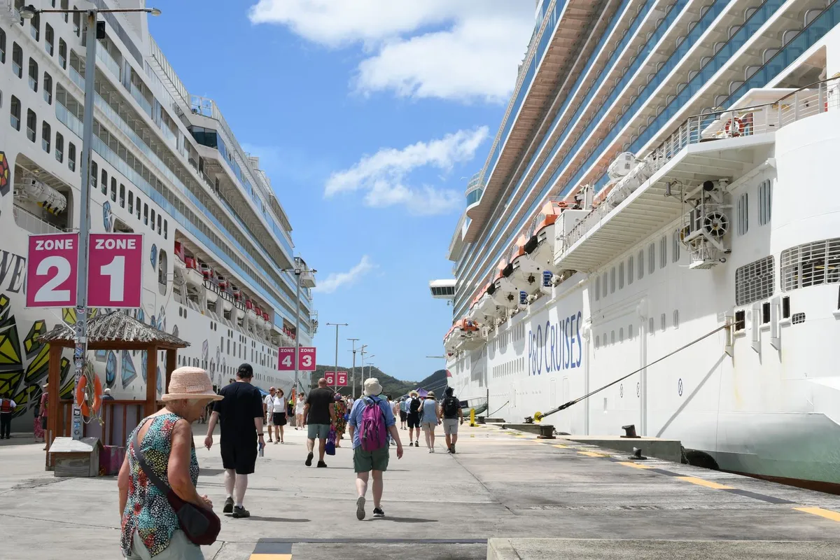 Passageiros caminhando no porto ao lado de um navio de cruzeiro atracado