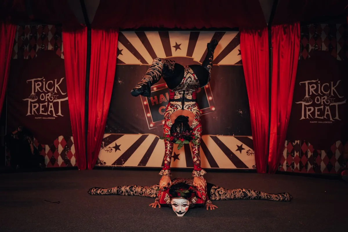Acrobatas em número de circo sob luzes no picadeiro