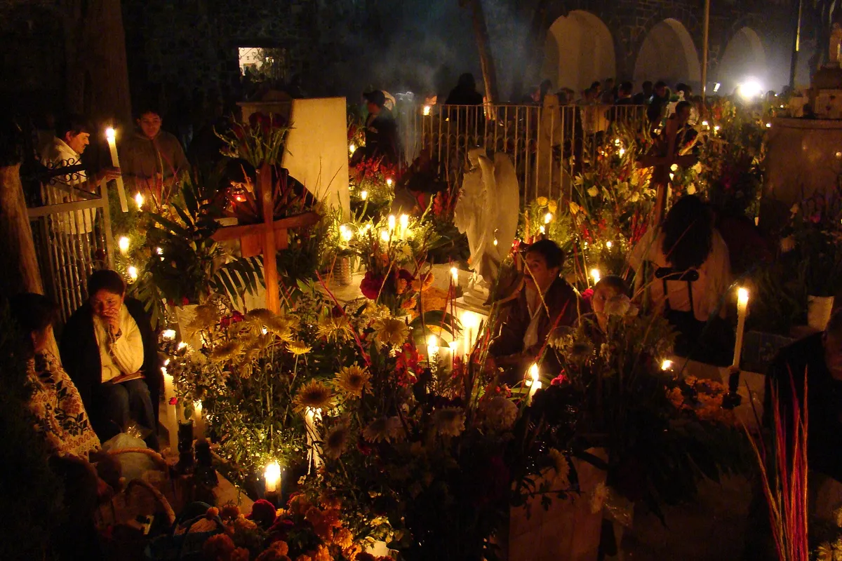 Famílias e velas no cemitério de Mixquic durante a noite de Día de Muertos