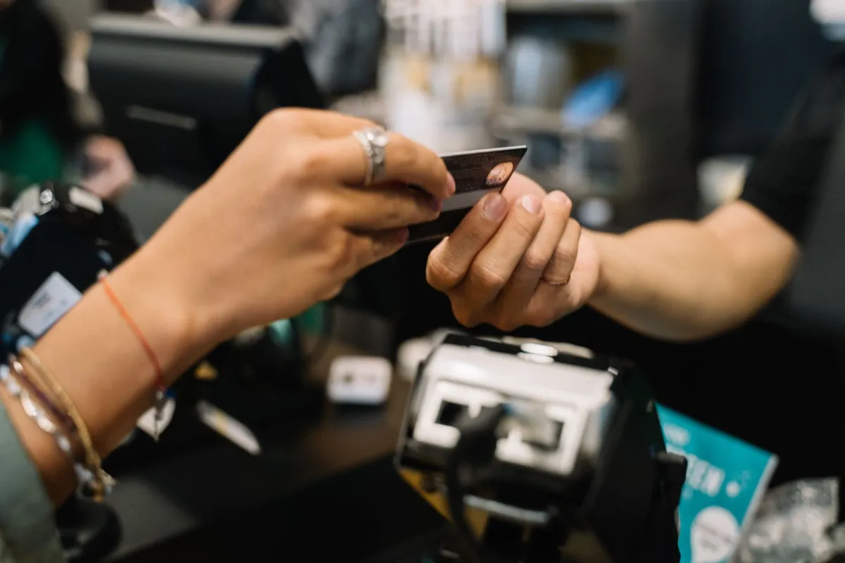 Pessoa entregando cartão bancário para pagamento