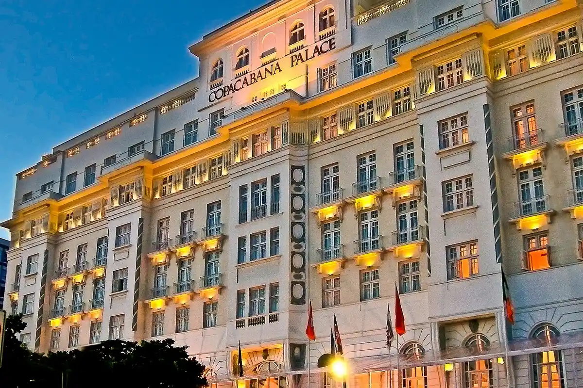Copacabana Palace iluminado ao anoitecer, em frente à praia de Copacabana, Rio de Janeiro