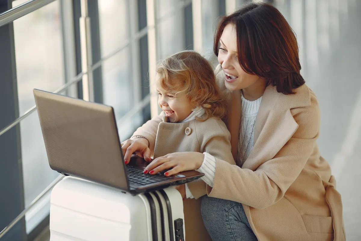 Mãe e filha reservando viagem no notebook