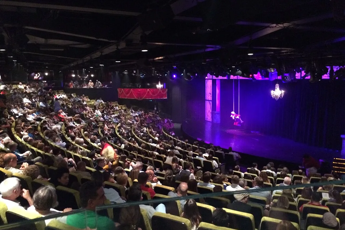 Plateia lotada no teatro do navio Norwegian Epic durante show acrobático