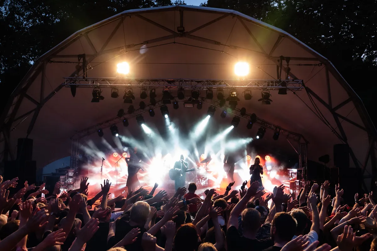 Plateia acompanha uma banda em palco iluminado