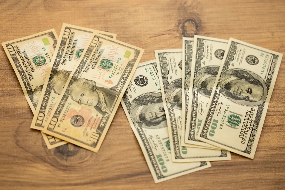 Notas de dólar americano sobre mesa de madeira