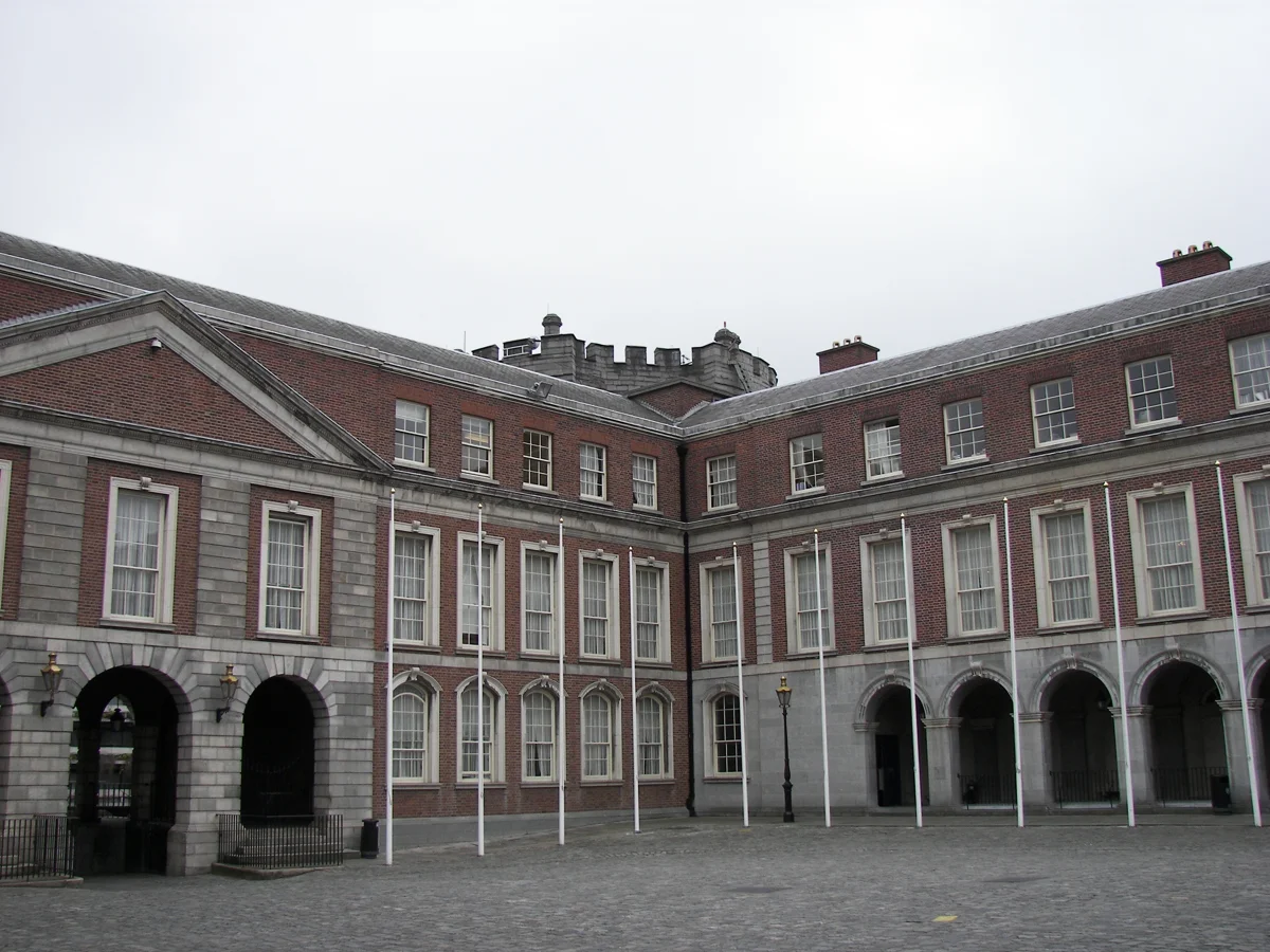 Pátio do Dublin Castle com fachadas de tijolos e a torre ao fundo.