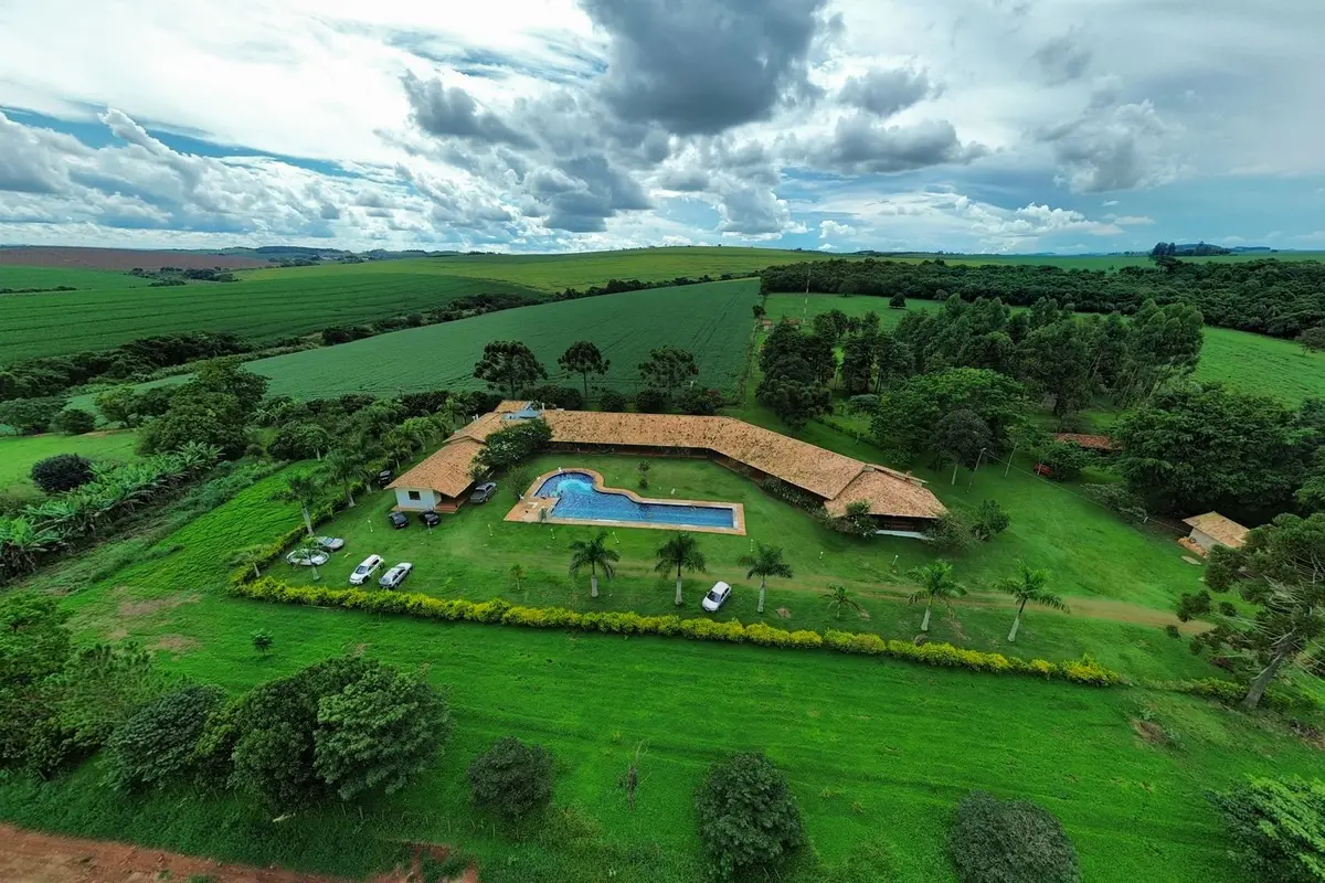 Vista aérea ilustrativa de uma propriedade rural com piscina e campo ao redor