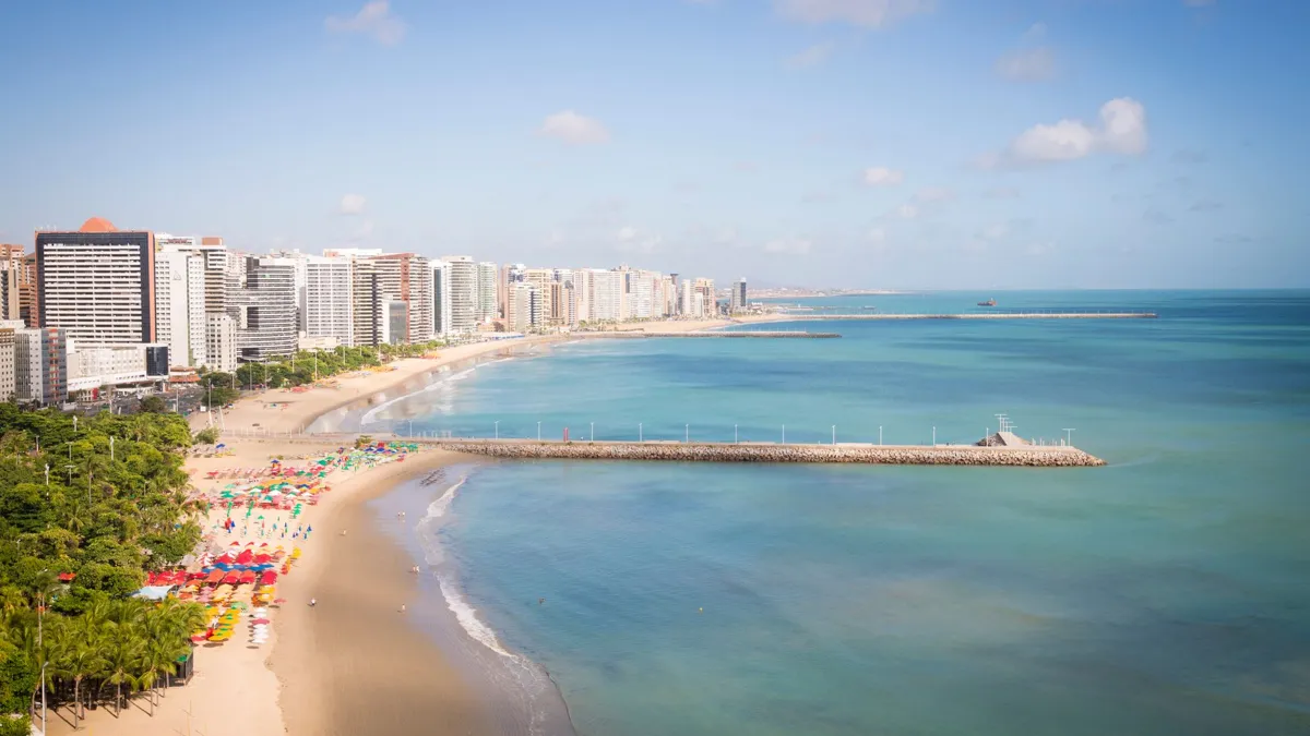 Orla da praia de Fortaleza, Ceará, com espigão e prédios ao fundo