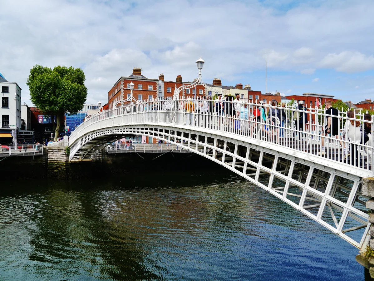 Ha’penny Bridge sobre o rio Liffey com pedestres em Dublin.
