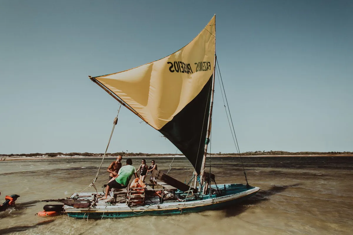Jangada de passeio com vela amarela na lagoa rasa de Jericoacoara, Ceará