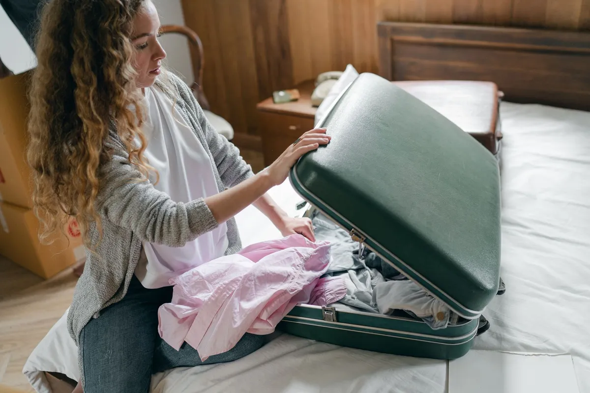 Viajante organizando roupas na mala antes de uma viagem