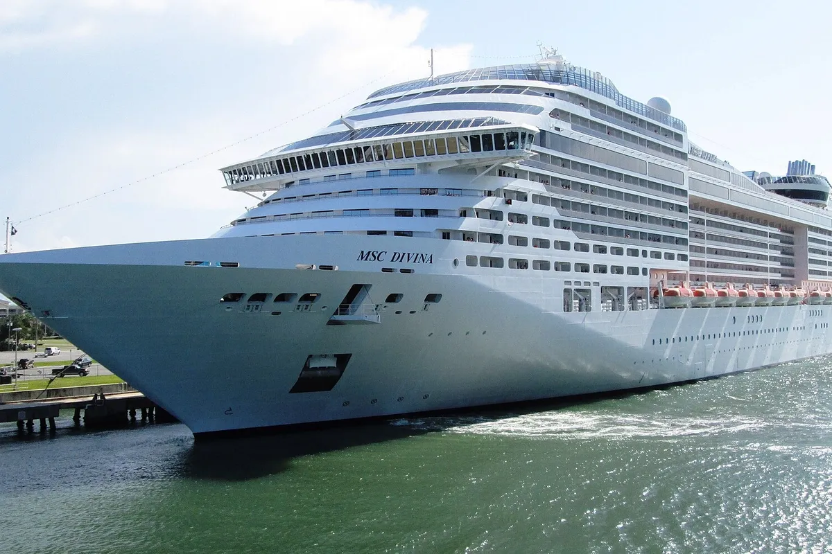Casco branco do MSC Divina com o logotipo da MSC, atracado em porto