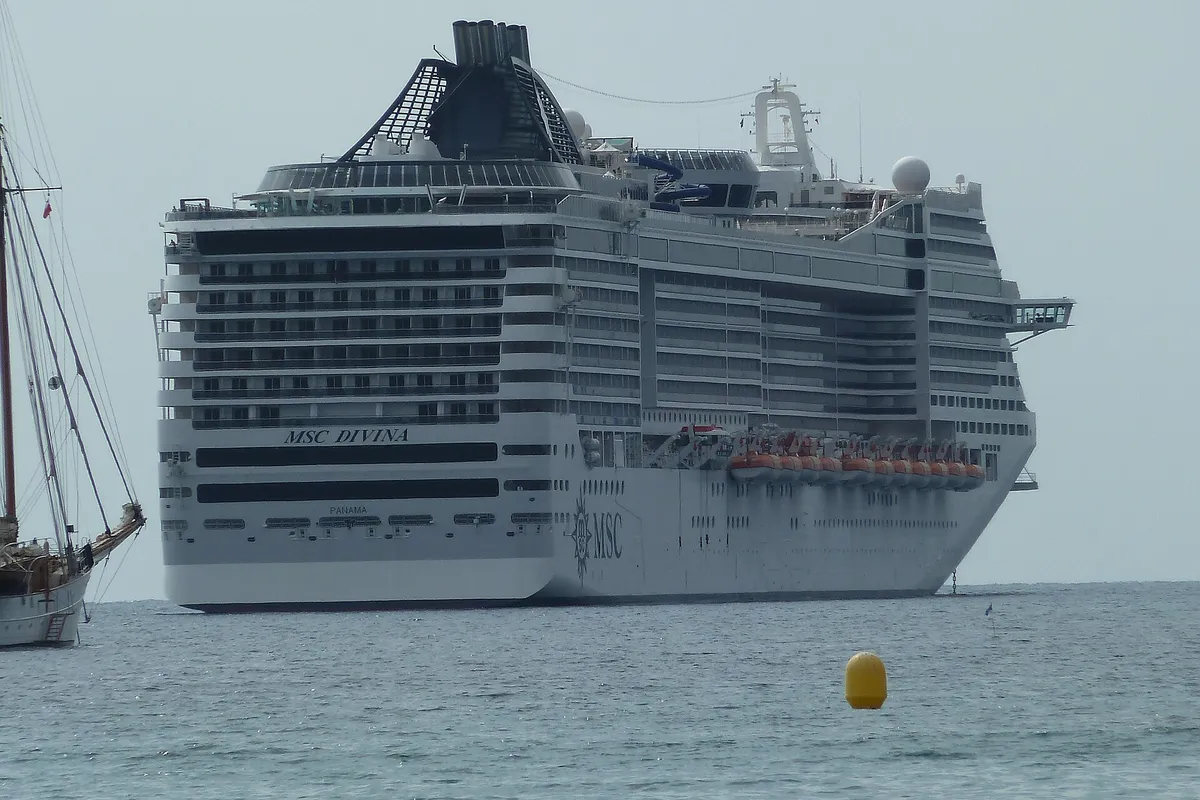 MSC Divina visto de popa, ancorado, com o nome do navio no casco