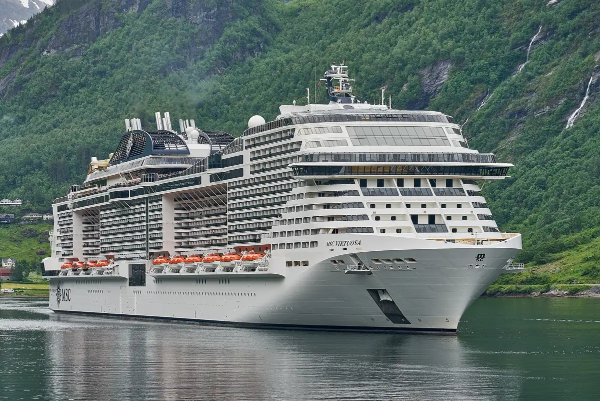 Navio MSC Virtuosa navegando em fiorde, visto de perto pela lateral