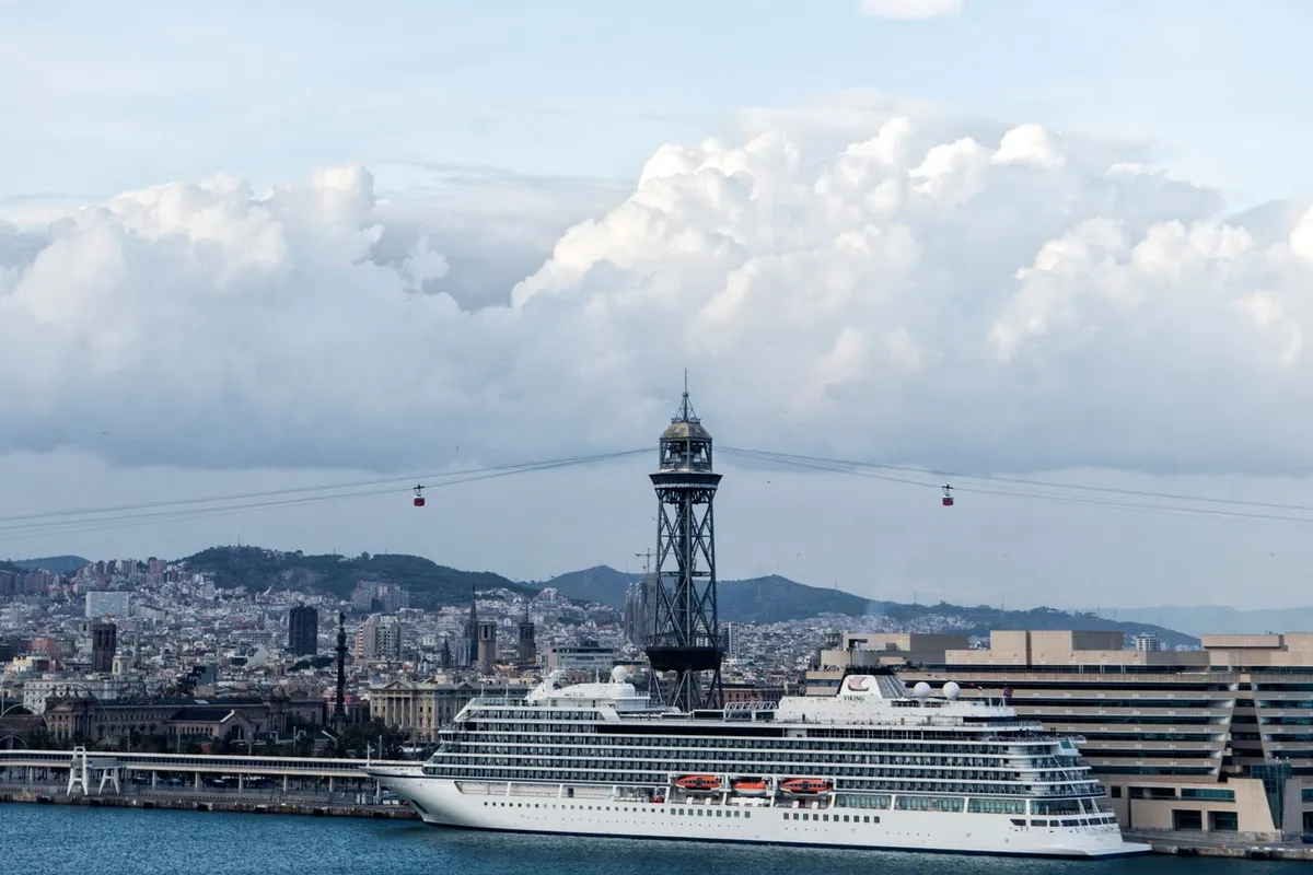 Navio de cruzeiro atracado no porto de Barcelona diante da Torre Jaume I