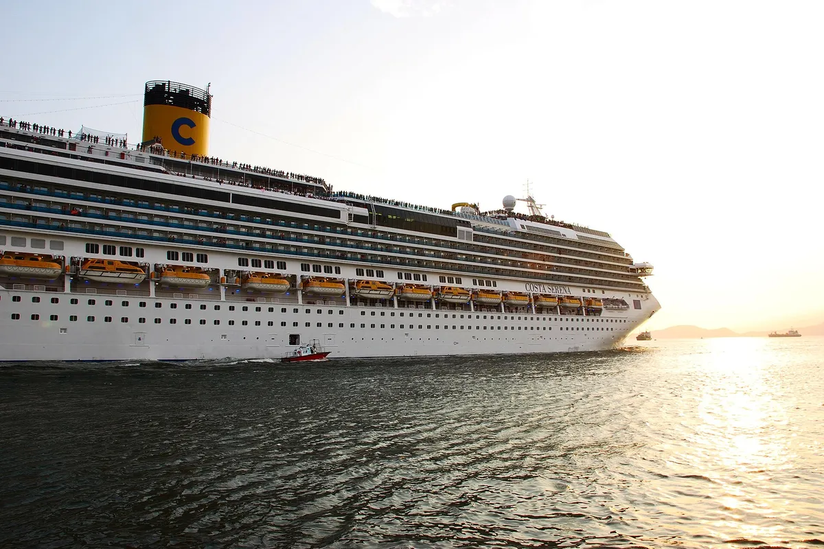Navio de cruzeiro navegando pelo canal do Porto de Santos ao entardecer