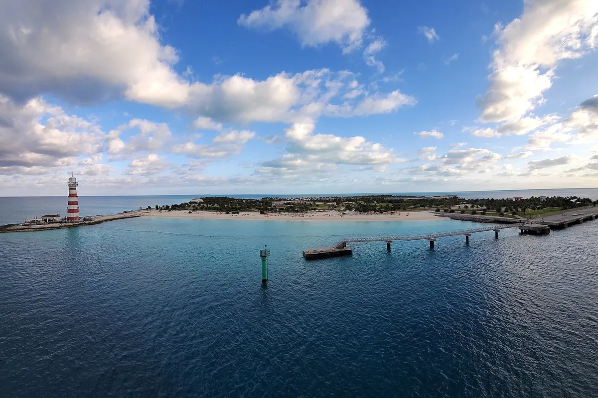 Ocean Cay com farol vermelho e branco, praia e píer vistos do mar